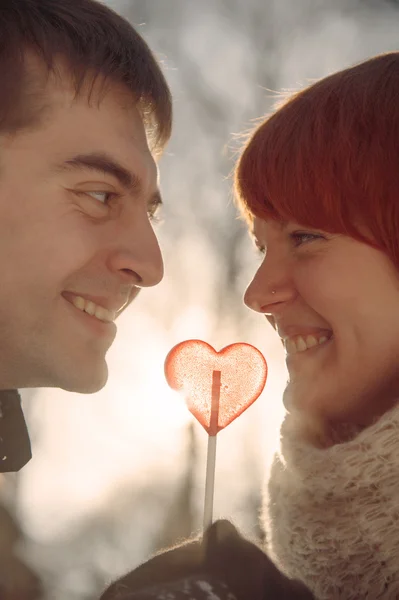 Couple in love hold heart shape lollipop — Stock Photo, Image