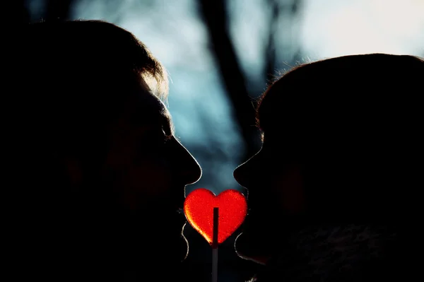 Silueta pár v lásce líbání srdce tvar lízátko — Stock fotografie
