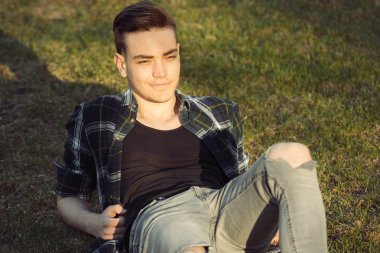 Yakışıklı adam Şehir Parkı çim üzerinde rahatlatıcı