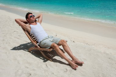 man om te zonnebaden op het strand