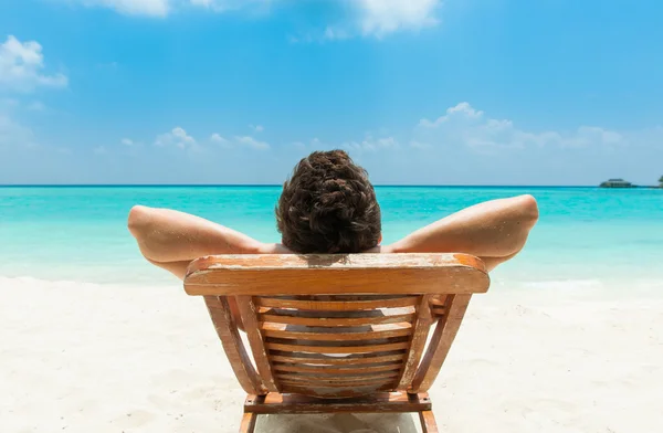 Homem relaxante na praia Fotos De Bancos De Imagens