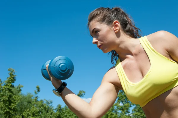 Woman stretching with dumbbells — Stock Photo, Image