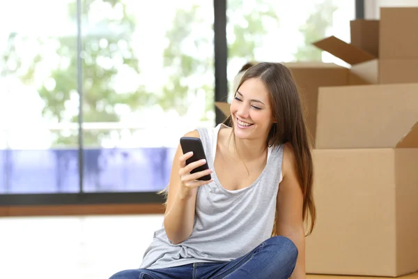 Женщина, переезжающая домой, пишет смс на смартфоне — стоковое фото