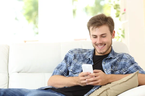 Mann benutzt zu Hause ein Smartphone — Stockfoto