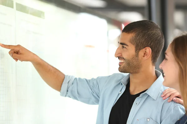 Arab man och vän consulting schema i en station — Stockfoto