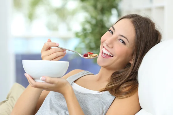 Menina feliz comer cereais em casa — Fotografia de Stock