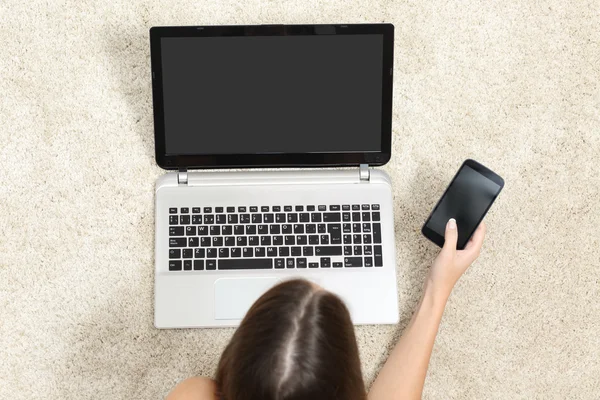 Вид сверху на девушку, работающую с планшетом и телефоном — стоковое фото