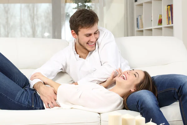 Playful couple tickling at home