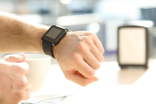 Man hand consulting en smartwatch i en bar — Stockfoto