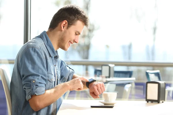 Homem usando um smartwatch em uma cafeteria — Fotografia de Stock