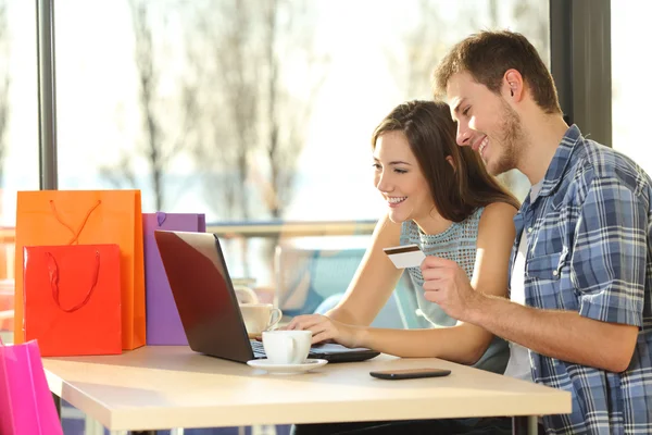 Couple buying online with shopping bags — Stock Photo, Image