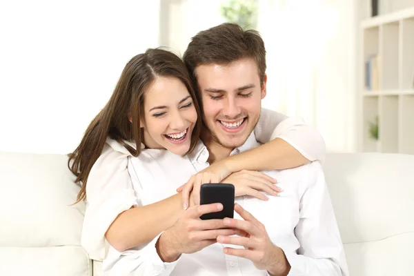 Pareja divertida compartiendo un teléfono inteligente — Foto de Stock