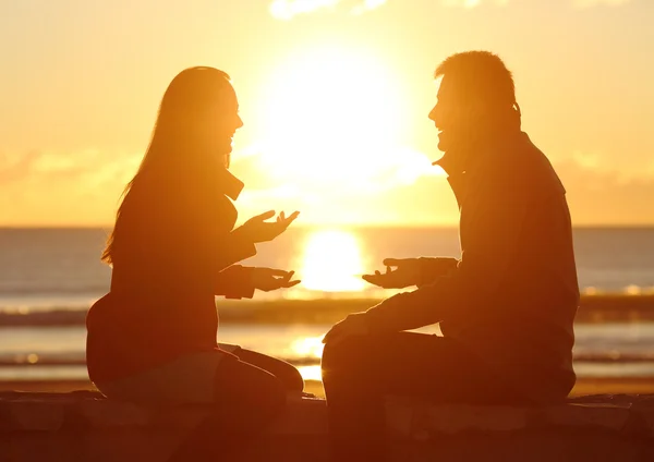 Par talar vid solnedgången på stranden — Stockfoto