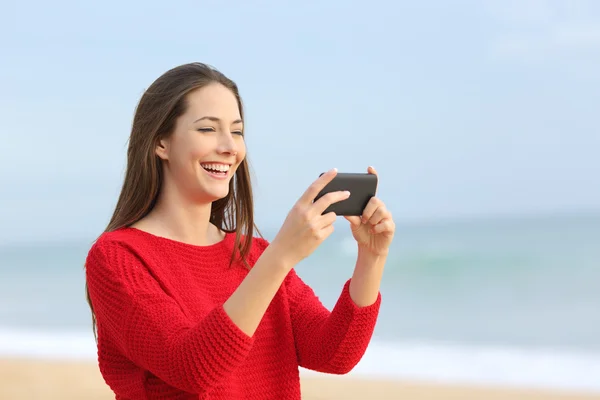 Chica riendo viendo vídeos en el teléfono inteligente — Foto de Stock