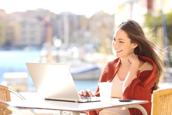 Woman watching videos in a laptop outdoors — Stock Photo, Image