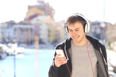 Akıllı telefondan müzik dinleyen genç