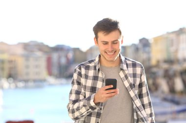Young man walking and using smart phone