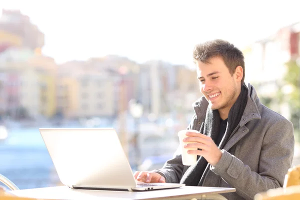 Elegant man using a laptop in a coffee shop — Stock Photo, Image