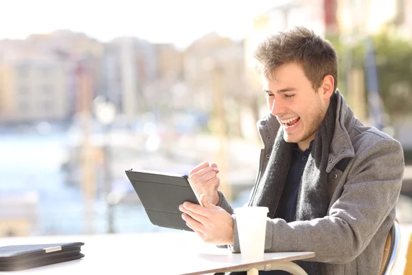 Euphoric winner winning and watching a tablet — Stock Photo, Image