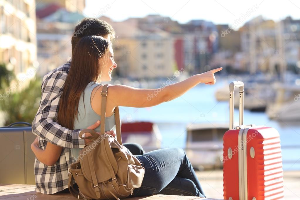 Couple of tourists pointing vacations destination