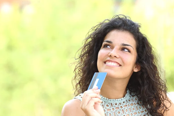 Comprador con una tarjeta de crédito pensando qué comprar — Foto de Stock