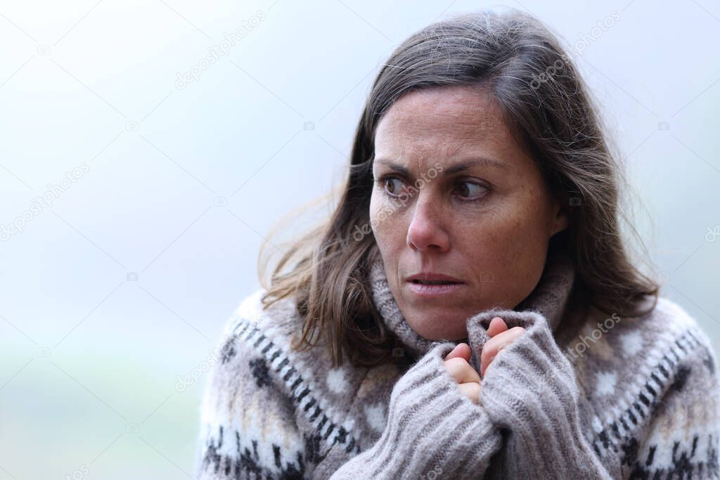 Scared middle aged woman standing in a forest a foggy day of winter