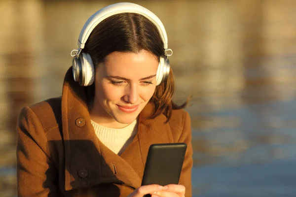 Zadowolona Kobieta Słuchająca Muzyki Słuchawkami Telefonem Komórkowym Plaży Zachodzie Słońca — Zdjęcie stockowe