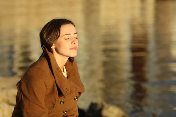 Mujer Relajada Invierno Respirando Aire Fresco Sentada Playa Atardecer —  Fotos de Stock