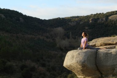 Yoga alıştırması yapan Yogi Yogası dağdaki bir uçurumun tepesinde