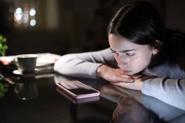 Üzgün kadın gecenin bir yarısı cep telefonuyla aramasını bekliyor.