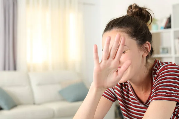 Beschaamde Vrouw Vermijden Fotoshoot Dekking Gezicht Met Haar Hand Woonkamer — Stockfoto