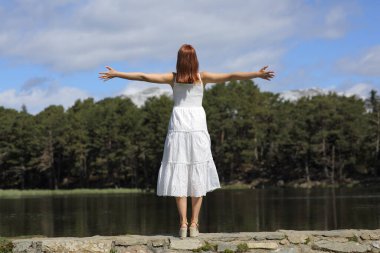 Dağda tatilini kutlayan beyaz elbiseli bir kadının arka plan portresi