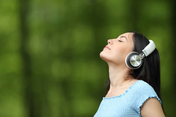 亚洲女人在公园里用无线耳机呼吸新鲜空气 听音乐 — 图库照片