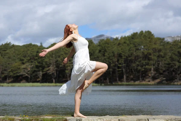 一个身穿白色衣服的快乐女人的侧面画像 她的腿在大自然中显得很美 — 图库照片
