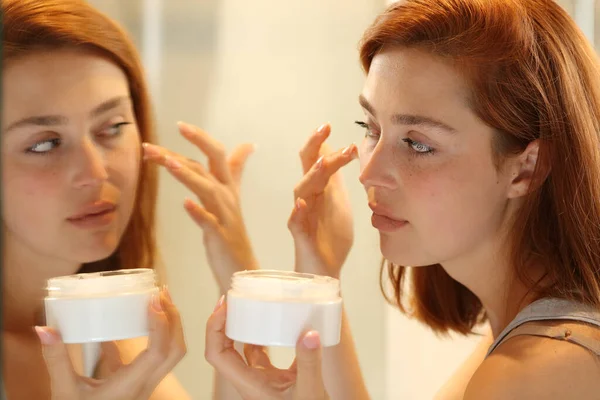 Woman Hydrating Face Skin Front Mirror Applying Moisturizer Cream Cheek — Stock Photo, Image