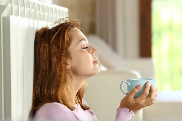 Perfil Uma Mulher Relaxante Aquecimento Radiador Segurando Xícara Café Casa — Fotografia de Stock