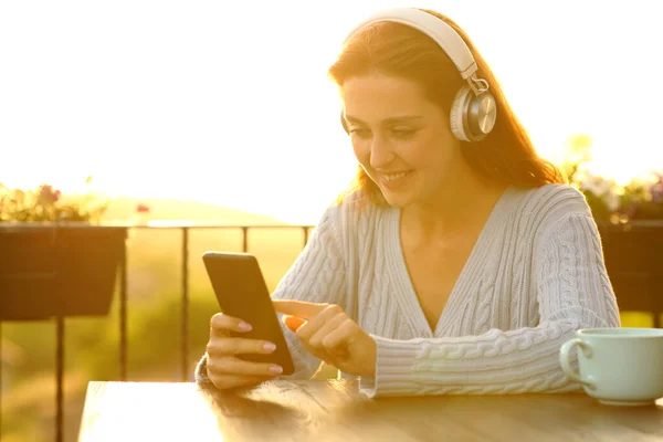 Happy Woman Weairng Headphones Listening Music Checking Smart Phone Balcony — Stockfoto