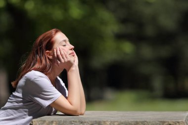 Profile of a woman resting sitting in a park a sunny day of summer