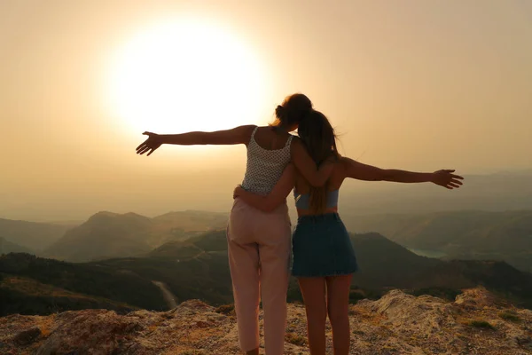二人の幸せな友人は山の中の夕日で腕を伸ばして祝う — ストック写真