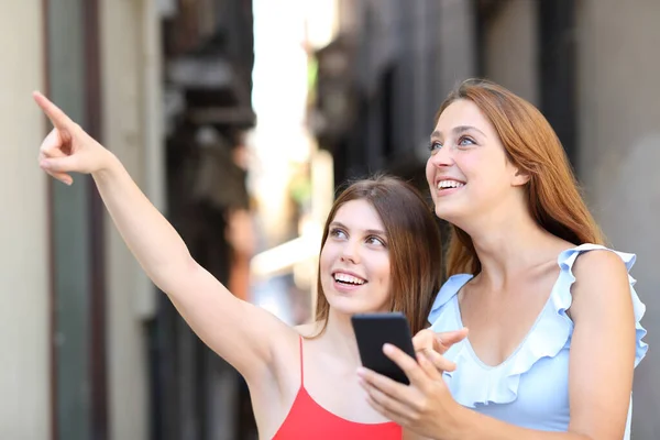 Dvě Šťastné Ženy Které Používají Chytrý Telefon Ukazují Ulici — Stock fotografie