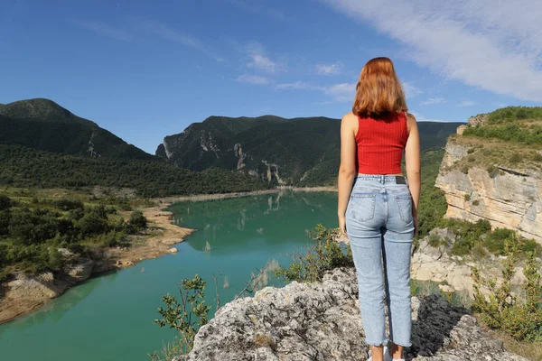 反观一位站在那里凝视着湖水的红衣女子的全身画像 — 图库照片