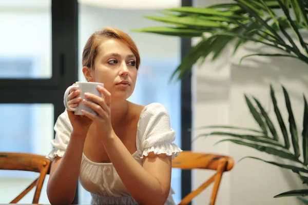 Serious Woman Drinking Coffee Thinking Looking Side Sitting Chair Home — Stock Photo, Image