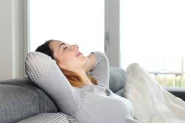 evde bir kanepede oturan mutlu rahat kadın