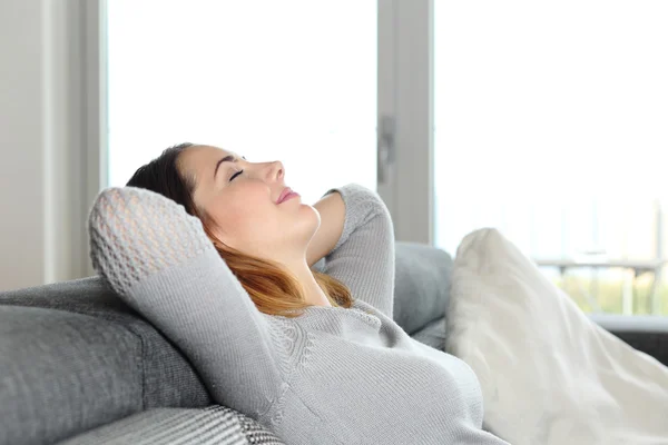 Gelukkig ontspannen vrouw rusten op een bank thuis — Stockfoto