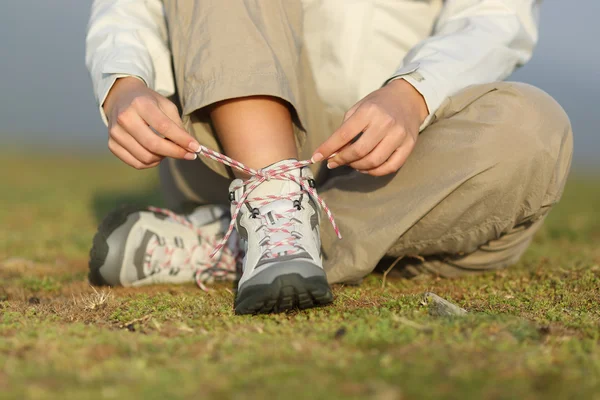 Caminante mujer atando cordones de botas — Foto de Stock