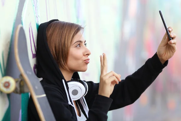 Skater adolescente menina tirando uma foto com câmera de telefone inteligente — Fotografia de Stock