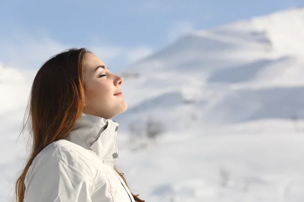 Mujer exploradora respirando aire fresco en invierno en una montaña nevada —  Fotos de Stock