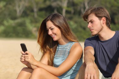 Onun kız arkadaşı manifatura telefon izlerken kıskanç erkek arkadaş