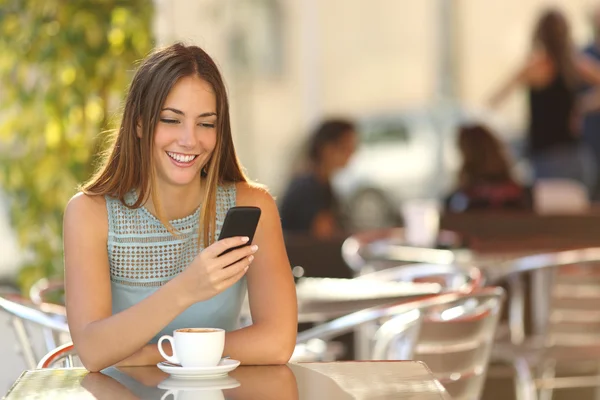 Chica mensajes de texto en el teléfono en un restaurante — Foto de Stock
