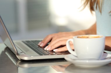 Eller kadın bir kafede bir dizüstü bilgisayar yazmaya